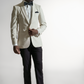 Selvsikker afroamerikansk mand i en beige skræddersyet jakkesæk og slips, der poserer med hænderne i lommerne mod en hvid baggrund