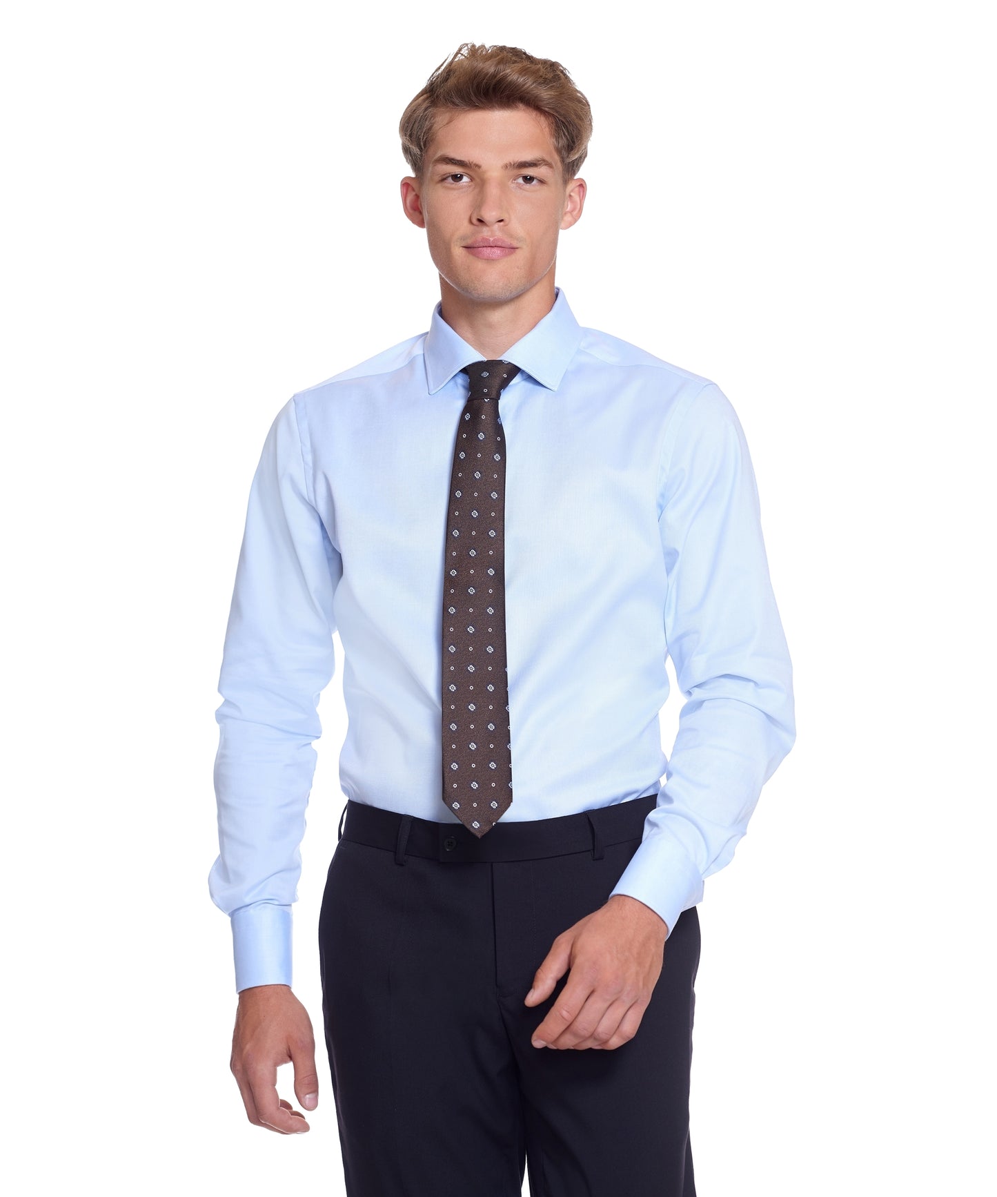 Businessmand i en lyseblå skjorte med et mønstret brunt slips, suppleret med sorte bukser