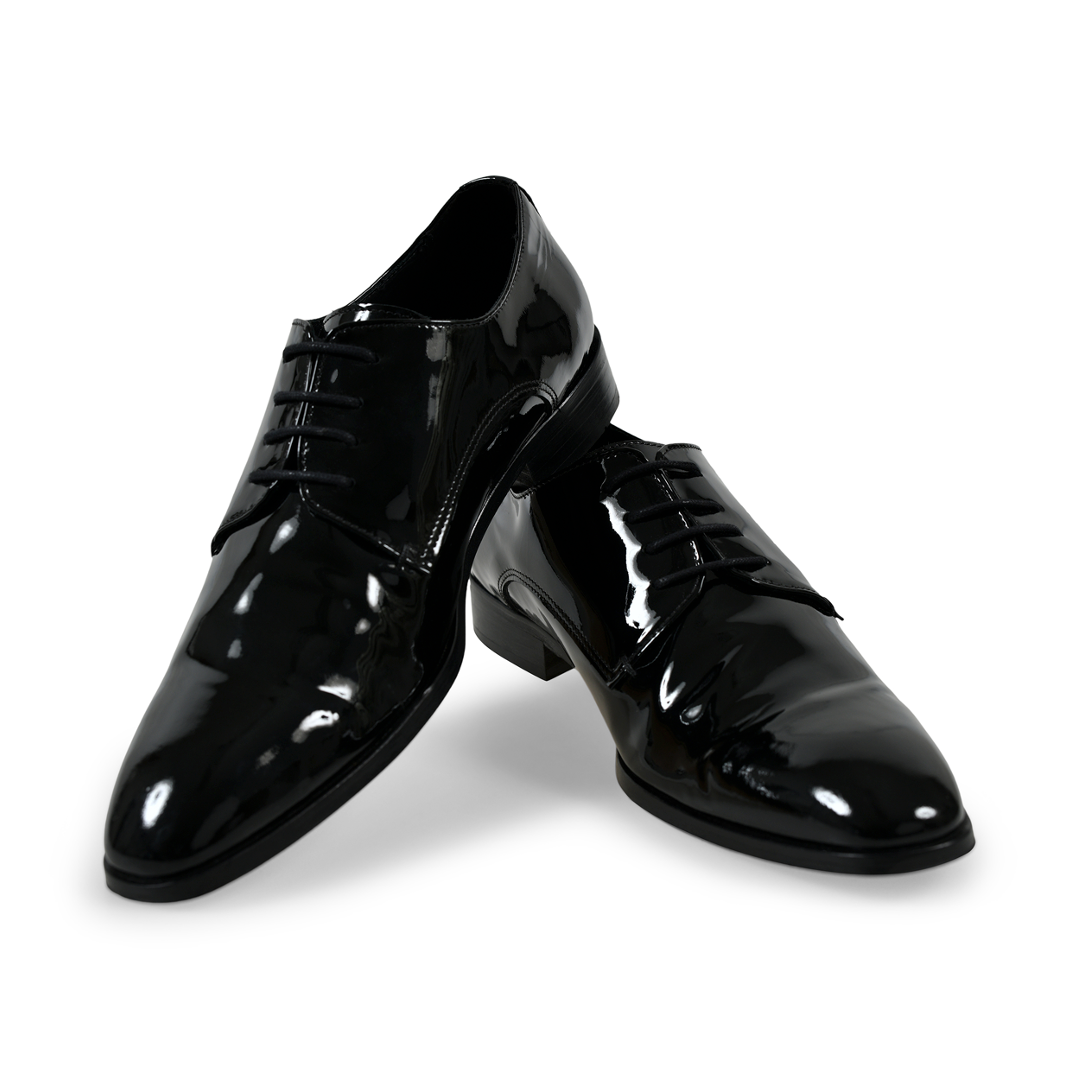 Blanke laklæder sorte oxford sko, fremhævet af deres reflekterende finish, mod en hvid indstilling