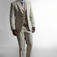Selvsikker afroamerikansk mand i en beige skræddersyet jakkesæk og slips, der poserer med hænderne i lommerne mod en hvid baggrund